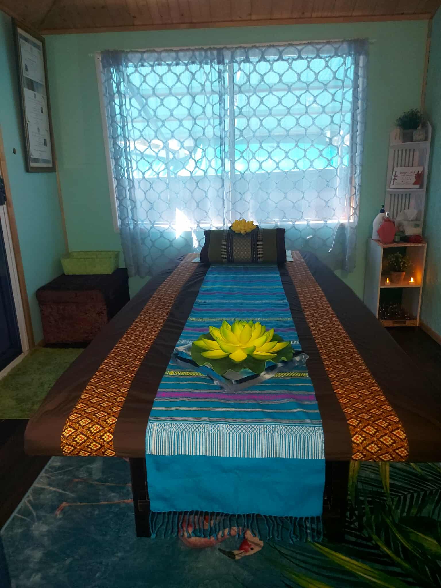A treatment room at Rung Nok Thai Massage, with a Thai cotton runner and a lotus on the table